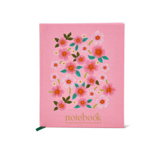 Pink hardcover notebook with embroidered style floral design and gold “notebook” text on the cover.