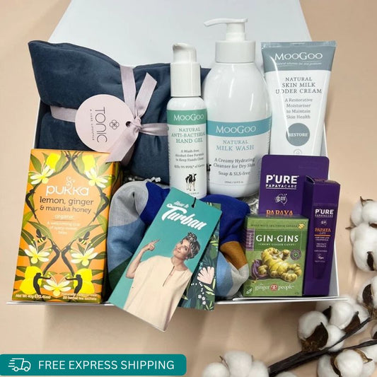 ChemoTherapy Maxi, MooGoo Milk Wash, Moisturiser, Hand Gel, Papaya Lips, GinGins, Pukka Tea and tonic Heat Pillow, and your selection of either slippers or scarf