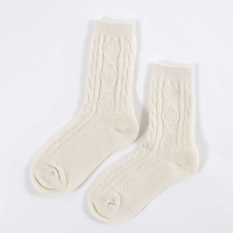 Cream cable knit crew socks with textured pattern displayed on a white background.