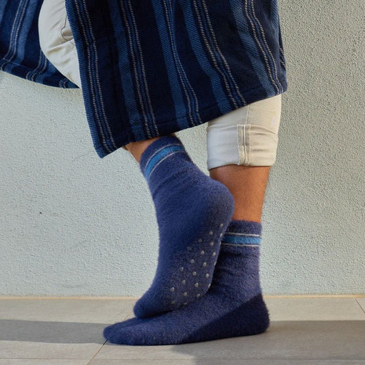 Men wearing navy blue lounge socks with non-slip grip soles for indoor comfort and warmth