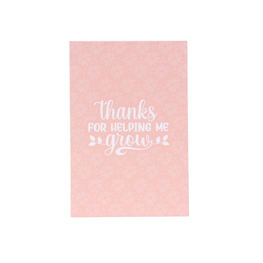 Pink daily planner and notepad set with “Thanks for helping me grow” text, sticky notes, and water tracker sections