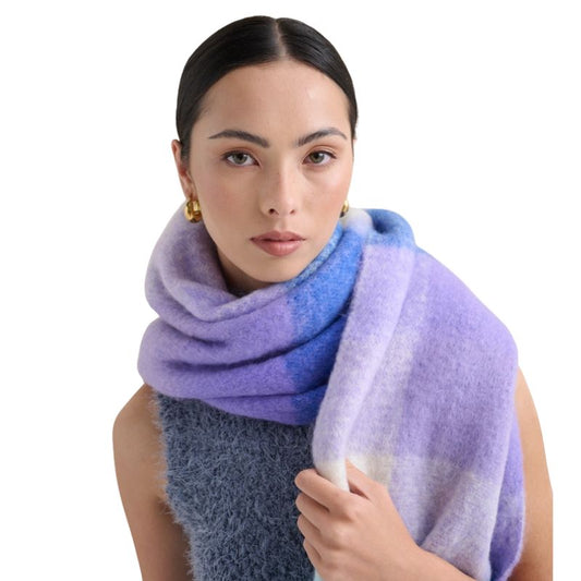 Woman wearing Betty Check Fluffy Scarf in lilac, blue and cream oversized pastel winter wrap with tassel fringe