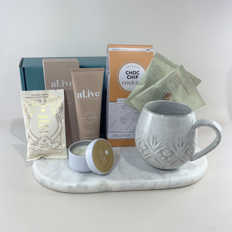 Carer gift box with speckled ceramic mug, Love Tea sachets, choc chip cookies, Al.ive Body hand cream, Loco Love chocolate and “You Are Amazing” candle