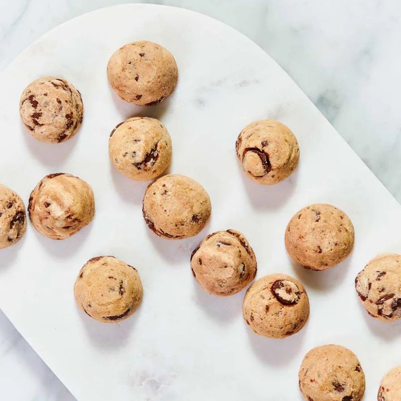 Byron Bay Cookies Milk Choc Chunk 100g pouch – golden cookies with milk chocolate chunks.