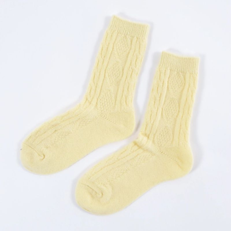 Soft lemon cable knit crew socks laid flat on white background.