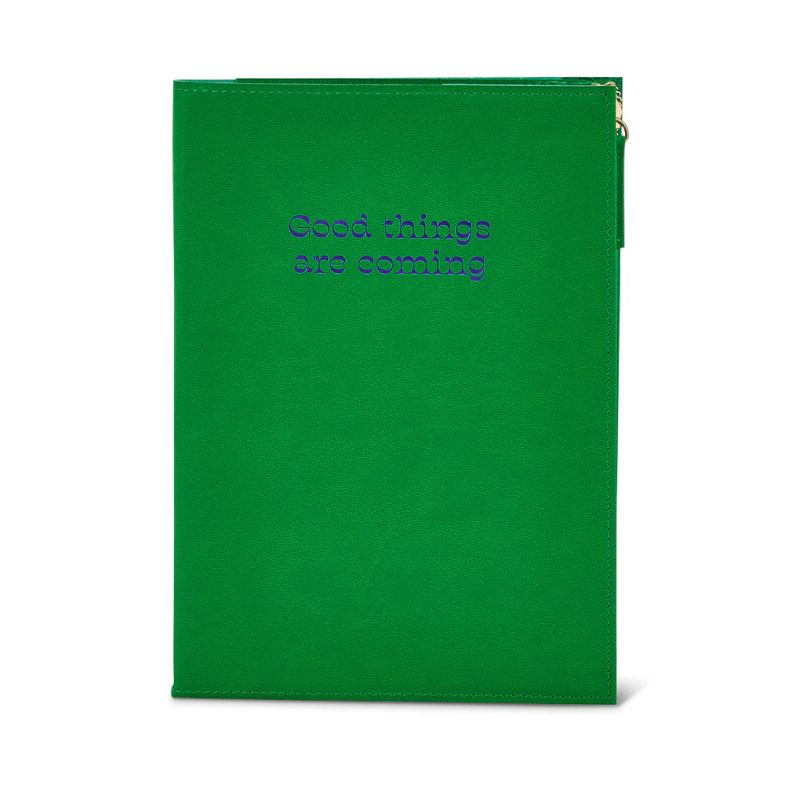 Green zip notebook with inspirational quote “Good Things Are Coming” embossed on the cover.