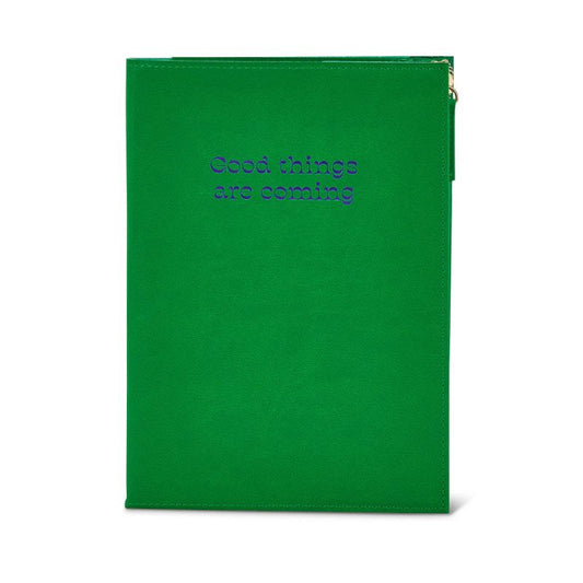 Green zip notebook with inspirational quote “Good Things Are Coming” embossed on the cover.
