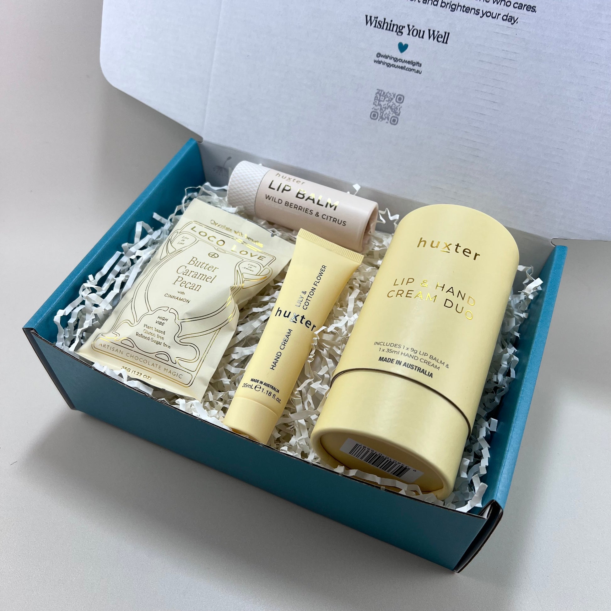 Mini Pamper Pack gift box with Loco Love chocolate truffle bar and Huxter hand cream and lip balm duo on a white background.