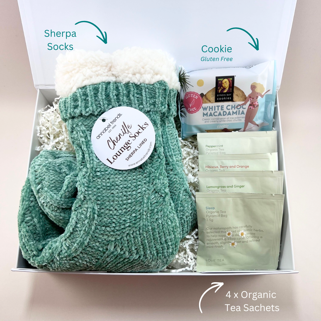 Premium white gift box containing the Mini Comforts Care Package; cosy socks, herbal tea and a gluten-free cookie. with labels