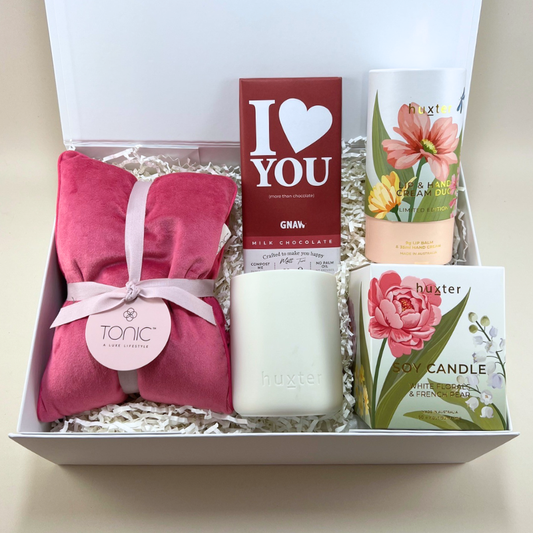 The Love You Mum Mothers Day Gift Box with Tonic pink heat pillow, GNAW I Love You chocolate, Huxter white florals and french pear soy candle and lip and hand cream duo in a white gift box