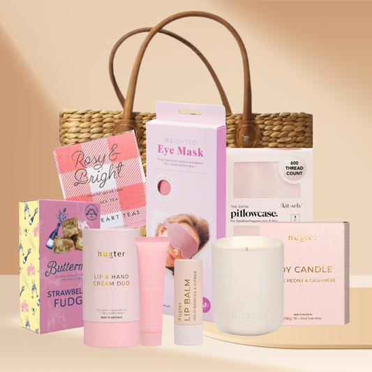 Rosy & Bright pamper gift box with candle, satin pillowcase, rose eye mask, hand and lip duo, and Christmas tea in a white gift box.