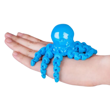 Blue octopus-shaped stress reliever toy on a hand against a white background
