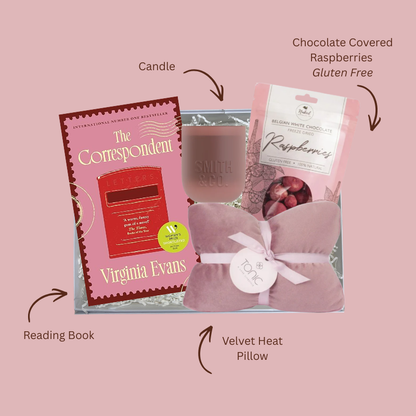 Close up of Just One More Chapter gift box showing The Correspondent bestselling novel, Smith and Co candle label, Tonic heat pillow ribbon and Naked Harvest white chocolate raspberry packaging
