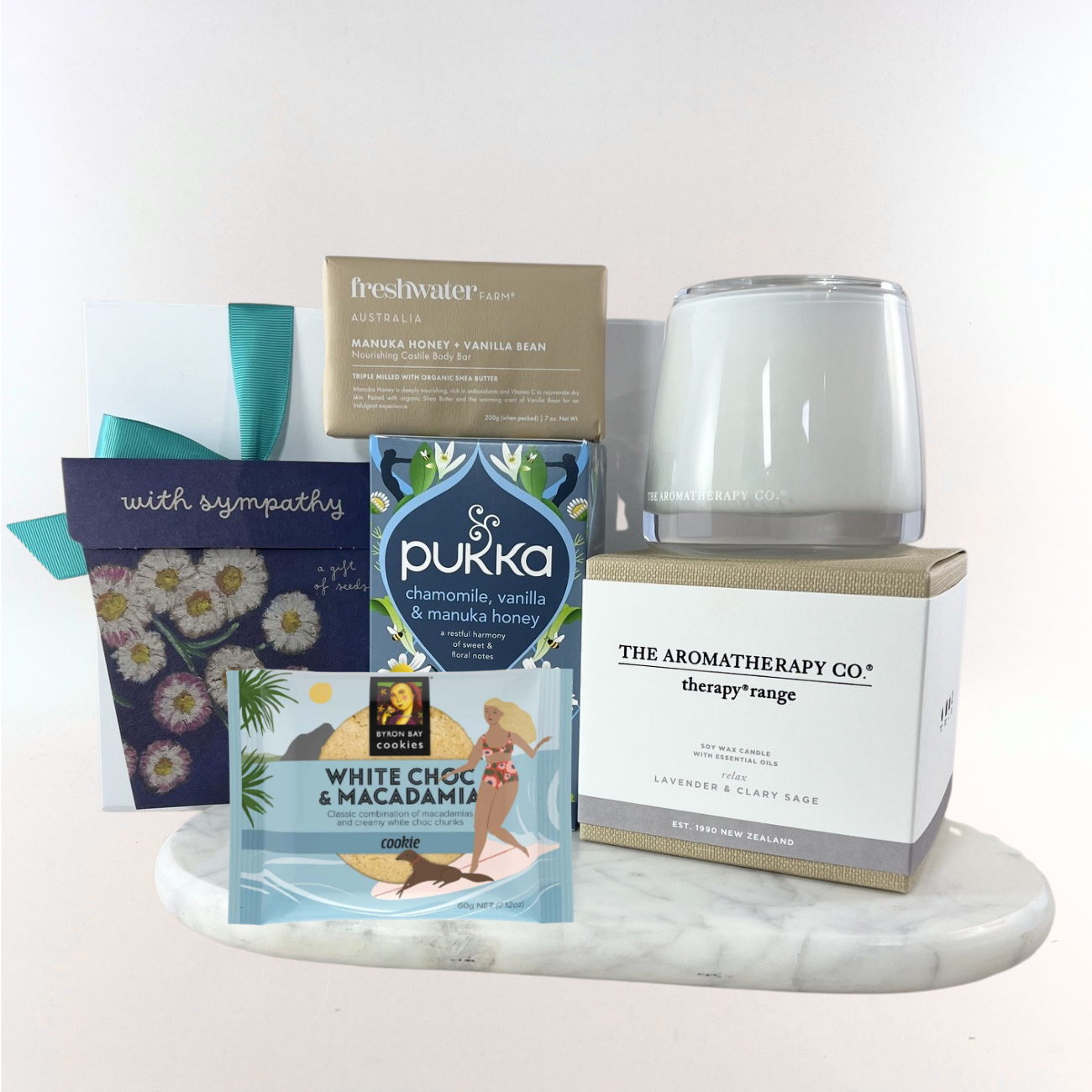Thinking of You sympathy gift box with a calming lavender candle, forget-me-not seed packet, chamomile herbal tea, manuka honey soap bar, white chocolate macadamia cookie and a 