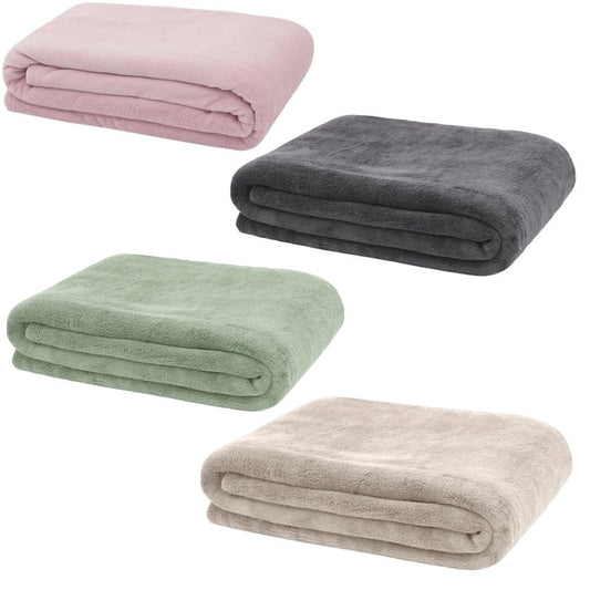 Soft microfiber fleece throw blankets in pink, green, charcoal grey and beige folded for cosy home comfort.
