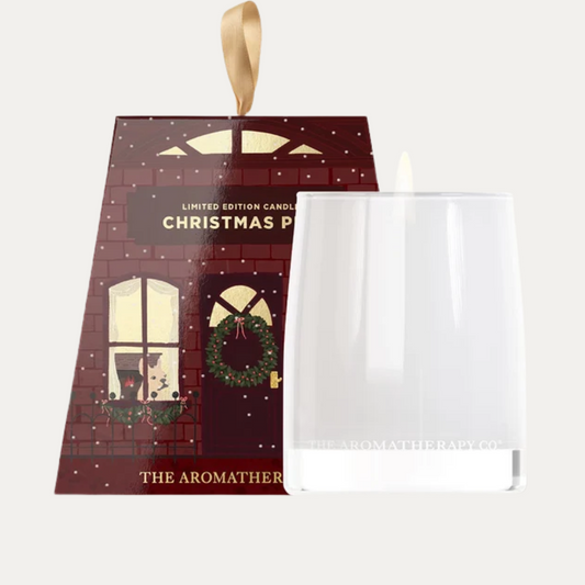 The Aromatherapy Co. Christmas Pud candle in a white glass vessel beside its red shopfront-style gift box