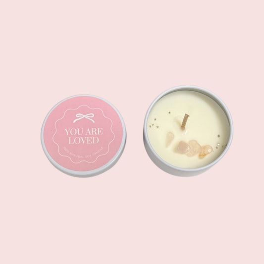 You Are Loved crystal soy candle in white tin with pink affirmation label and decorative crystal chips.