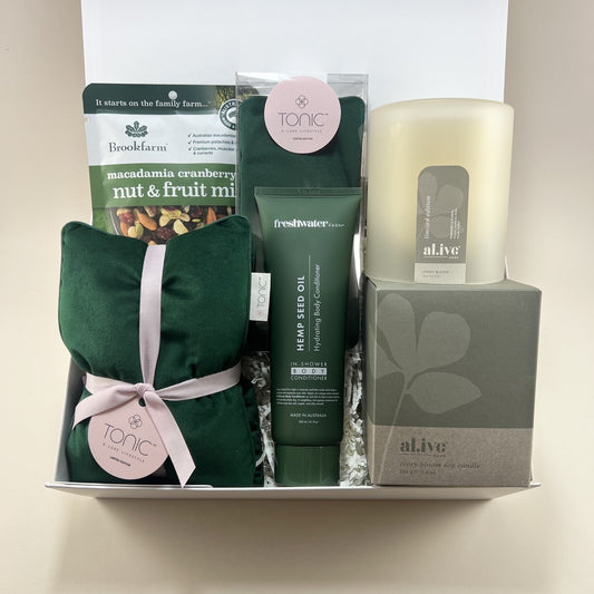 Forest green luxury pamper gift box with velvet heat pillow, eye mask, candle and body care products