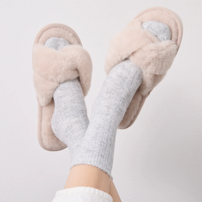 Cream knotted slippers with a soft faux fur upper and rubber sole.