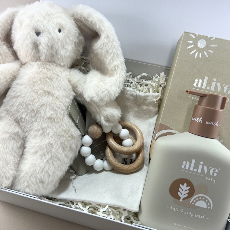 Detail shot of New Baby Joy Box featuring soft Alimrose cuddly bunny, colourful Alimrose teether toy and Al.ive Baby gentle natural hair and body wash
