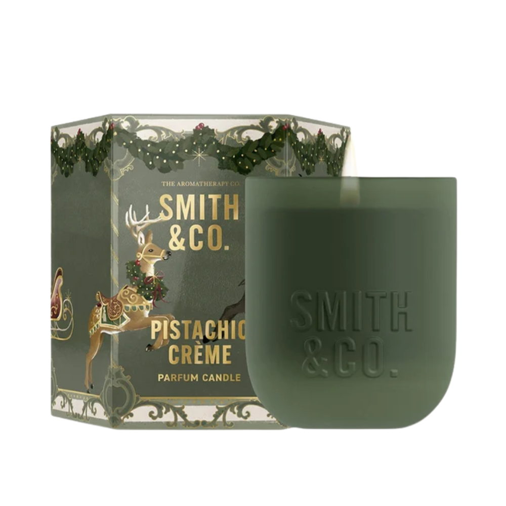 Smith & Co. Pistachio Crème scented candle in a matte green vessel beside its festive reindeer gift box