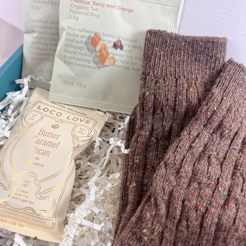 The Little Cosy Gift Box with cosy socks, Loco Love chocolate bar and two organic Love Tea sachets in a signature gift box Close Up Image